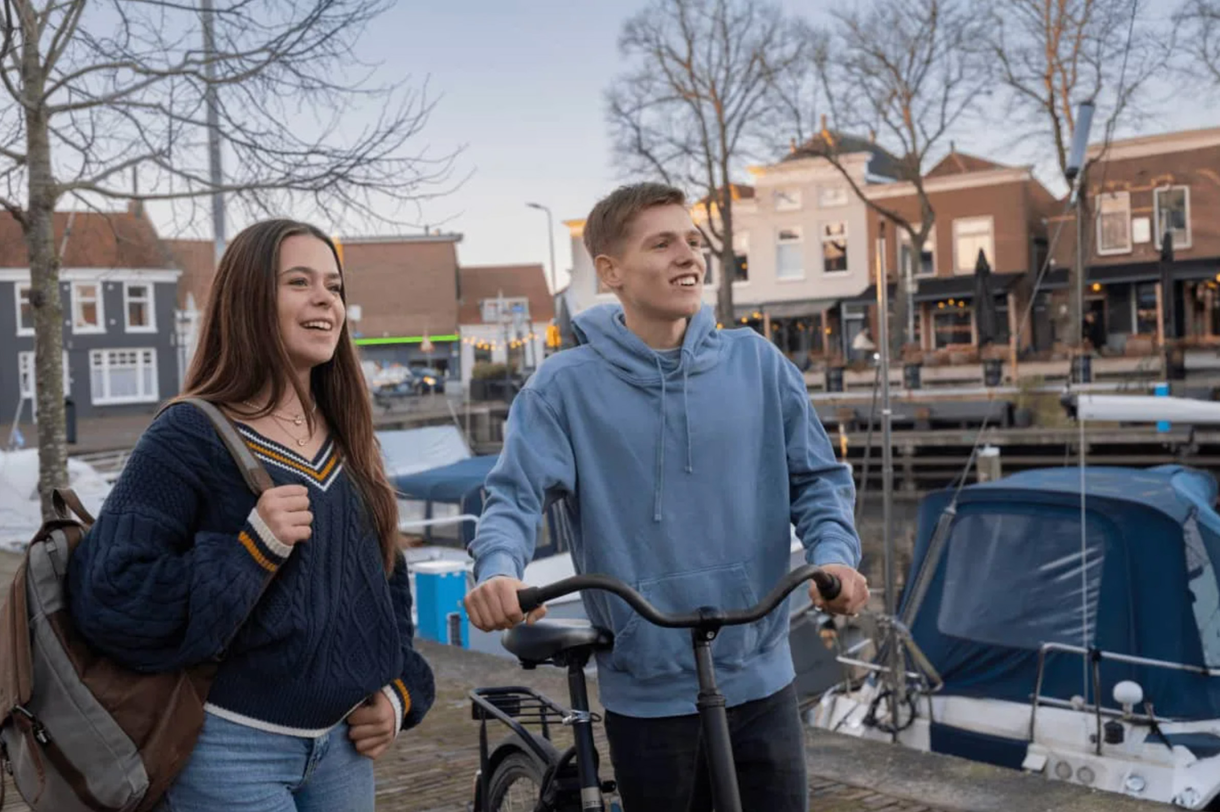 Tieners met fiets vriendelijk lachend bij haven Middelharnis